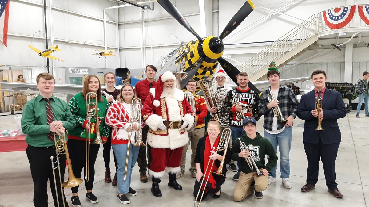 Jazz Band December 2021 at the Tri State Warbird Museum standing with Santa Claus in front of an airplane
