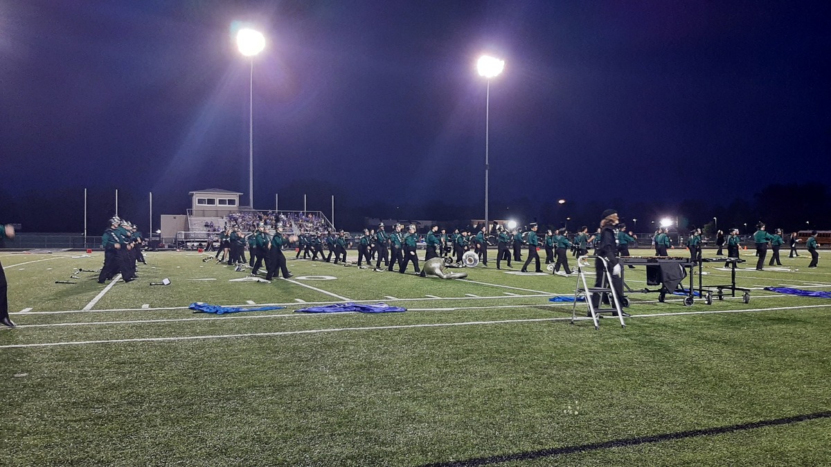 high school stadium filled with band members performing halftime show